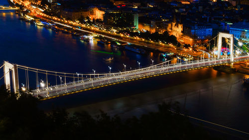 View of bridge over river at night