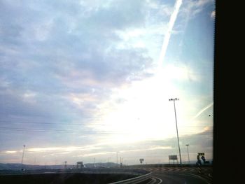 Electricity pylon against cloudy sky