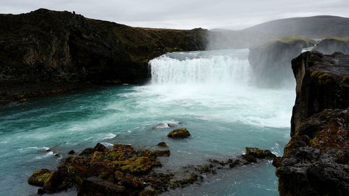 Scenic view of waterfall against sky