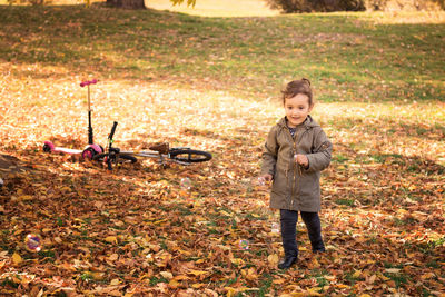 Smiling girl standing at park during autumn