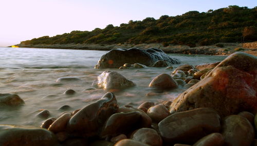 Rocks in sea against sky