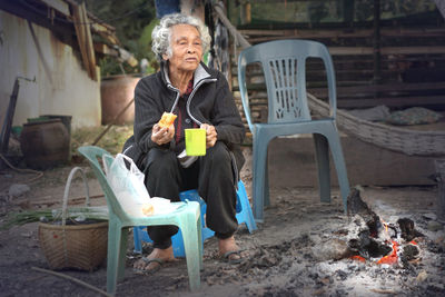 Old women sit by the fire and drink hot water in winter.