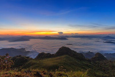 Scenic view of mountain against cloudy sky during sunset