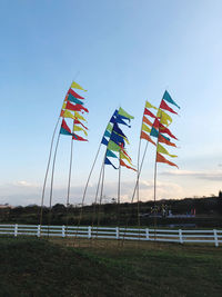 Low angle view of flags on land against sky during sunset