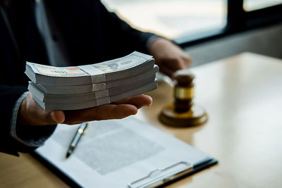 Close-up of hand holding books on table