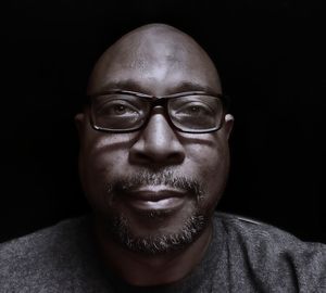 Close-up portrait of man against black background