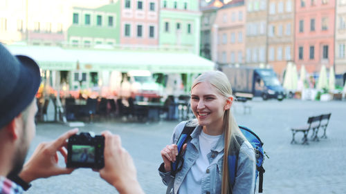 Portrait of woman photographing in city