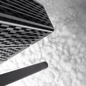 Low angle view of skyscrapers against cloudy sky