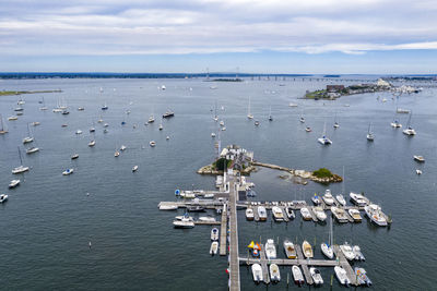 High angle view of sailboats moored in sea against sky