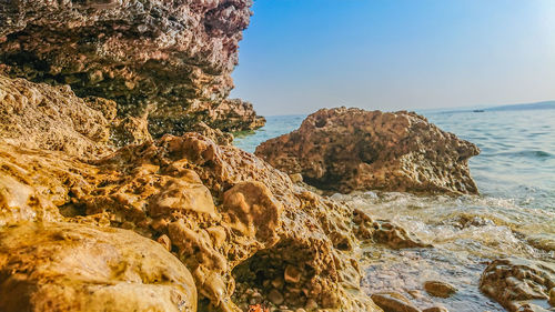 Rock formation on beach against sky