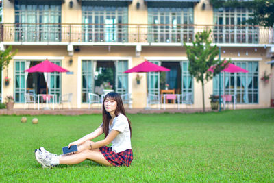 Portrait of young woman sitting on field