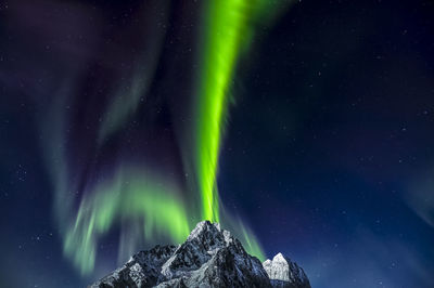 An aurora eruption above store nappstind in flakstad island,