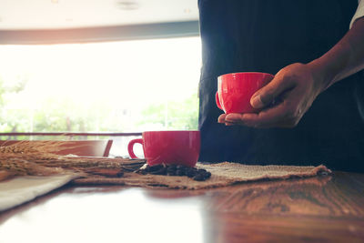 Hand holding coffee cup on table