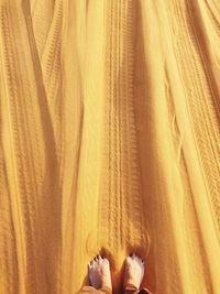 Low section of person standing in sand