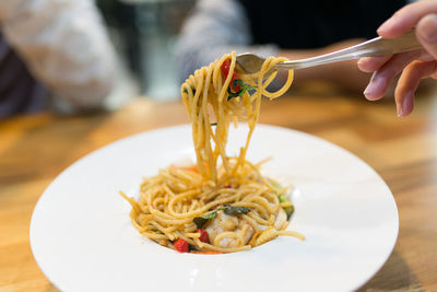 Close-up of hand holding ice cream in plate