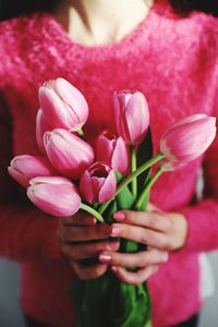 Close-up of hand holding pink tulip