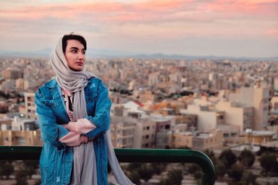 Full length of woman standing against buildings in city