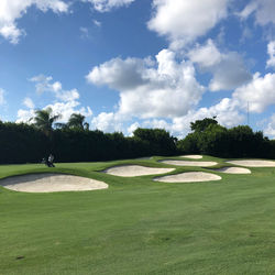 Scenic view of golf course against sky