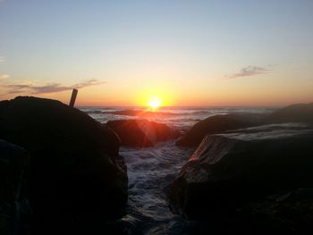 Rocks on sea shore at sunset