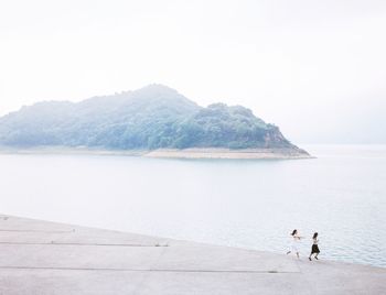 Scenic view of sea with mountain in background