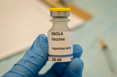 Close-up of human hand holding bottle in laboratory