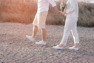 Low section of couple walking on ground