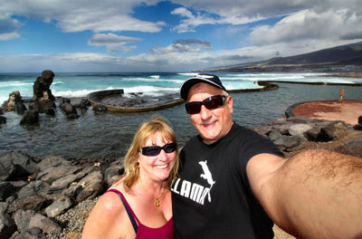 Portrait of smiling young couple on beach