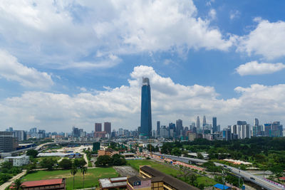 Aerial view of buildings in city against cloudy sky