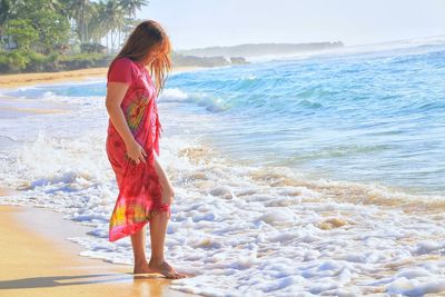 Full length of woman standing on beach