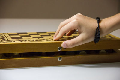 Cropped hand of woman opening chess board