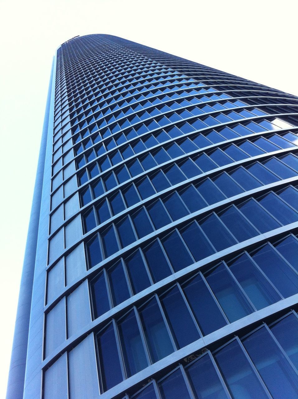 architecture, low angle view, building exterior, built structure, modern, office building, skyscraper, tall - high, city, glass - material, tower, building, reflection, clear sky, sky, day, tall, outdoors, no people, window