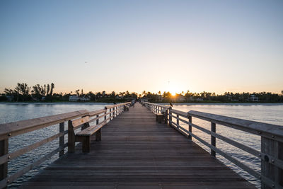 Pier over sea against sky during sunset