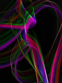 Close-up of multi colored light painting against black background