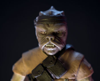 Close-up of buddha statue against black background