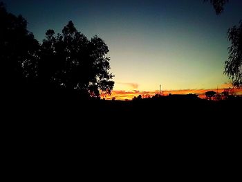 Silhouette of trees against sky at sunset