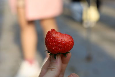 Cropped hand holding strawberry