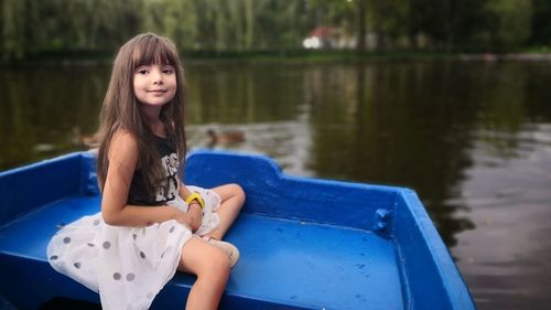 Girl sitting in boat on lake
