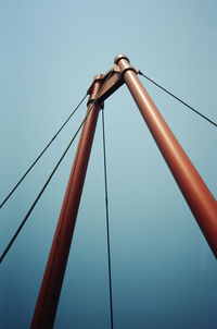 Low angle view of telephone pole against clear blue sky