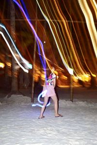 Blurred motion of woman dancing at night