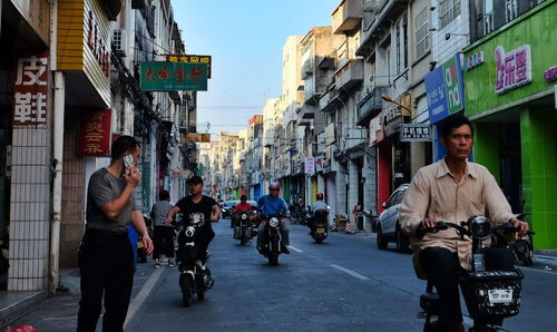 People riding bicycle on road in city