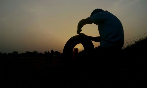 Silhouette of woman against sky at sunset