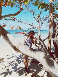 Full length of boy standing by tree against plants