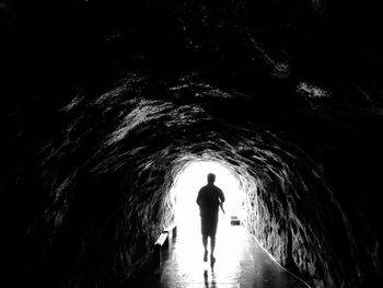 Rear view of man walking in tunnel