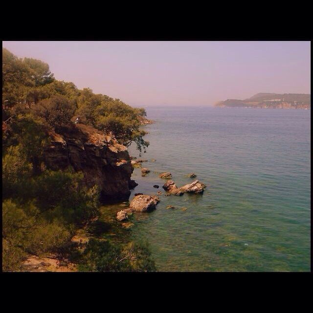 transfer print, water, auto post production filter, sea, tranquil scene, scenics, tranquility, beauty in nature, horizon over water, nature, rock - object, sky, rock, rock formation, idyllic, clear sky, cliff, coastline, high angle view, outdoors