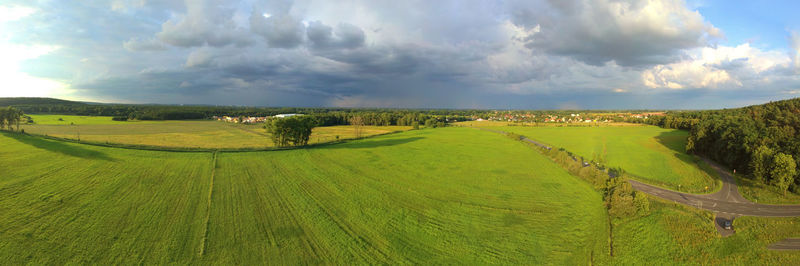 Panoramic view of agricultural field against sky