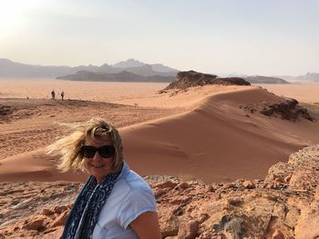 Portrait of woman wearing sunglasses on sand