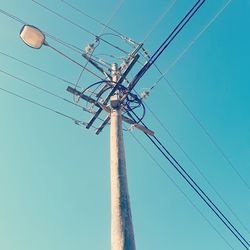 Low angle view of electricity pylon against sky