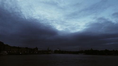 Bridge over river against cloudy sky