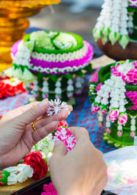 Close-up of woman hand holding flowering plant