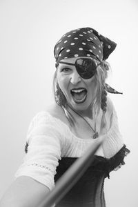 Woman in costume fighting with sword against white background